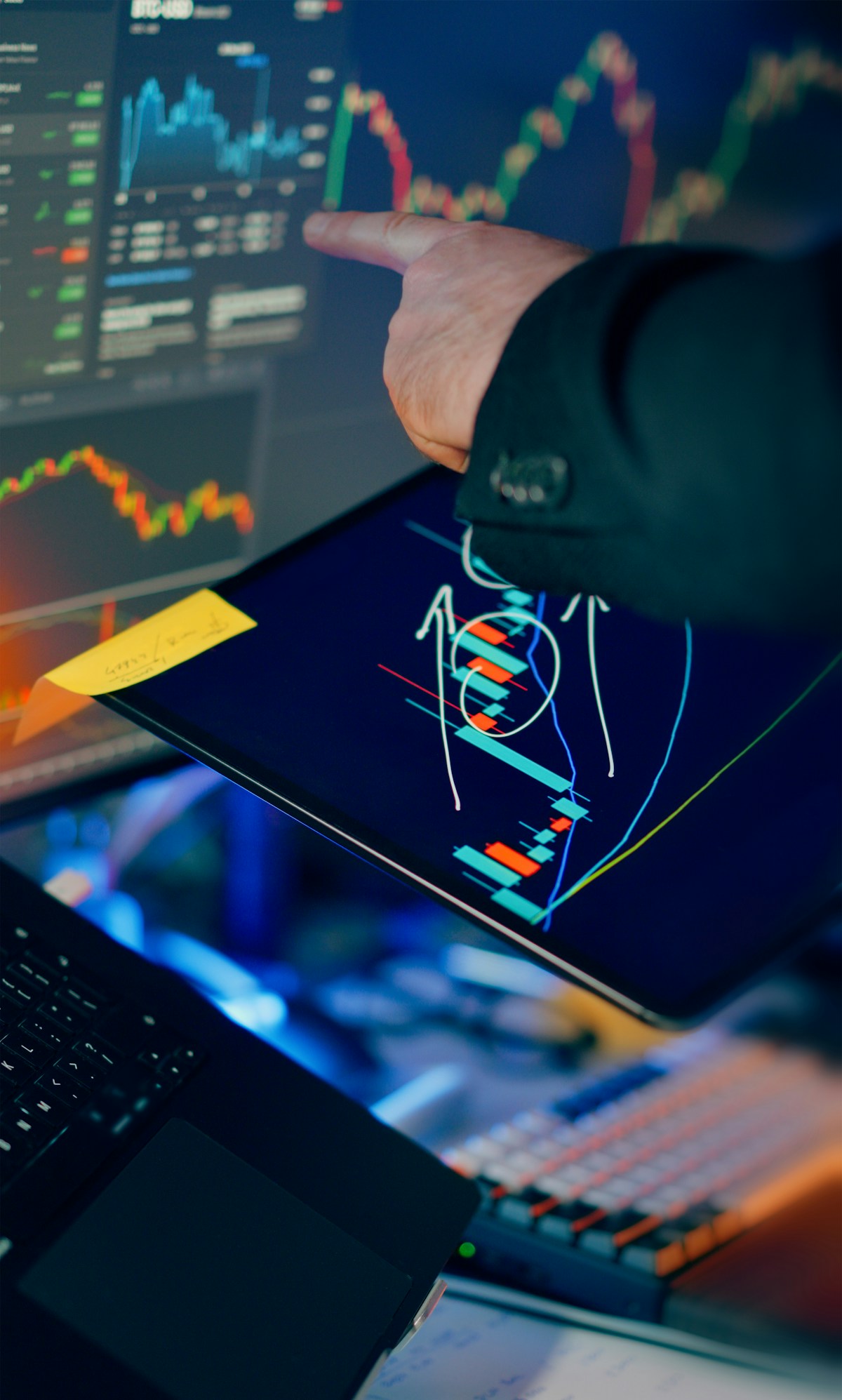 Analyst marking up a candlestick chart on a tablet